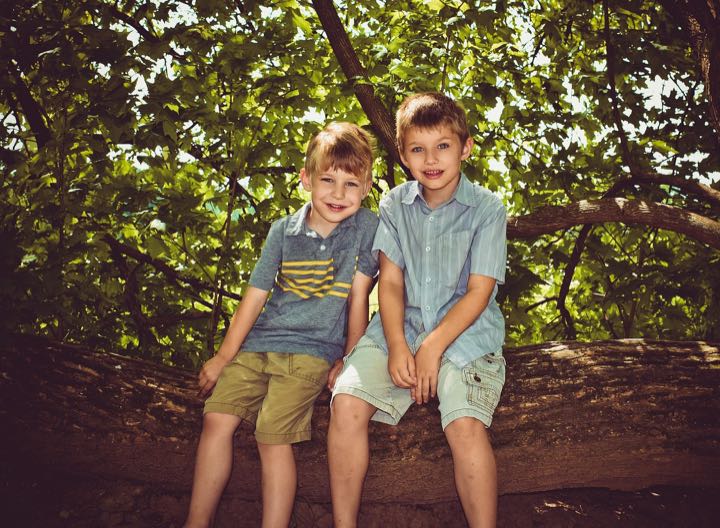 Two brothers sitting together in the woods