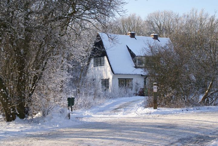 A house and driveway after a snowfall