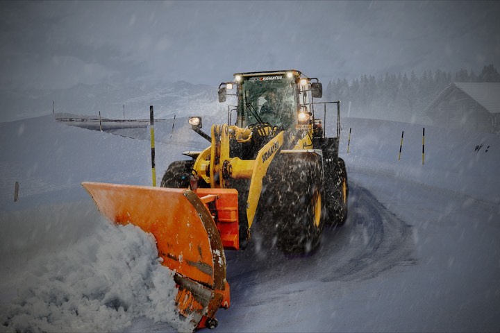 A loader pushing snow at night