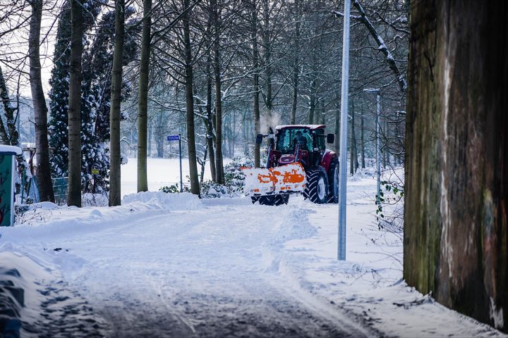 A small tractor clearing a snowy path